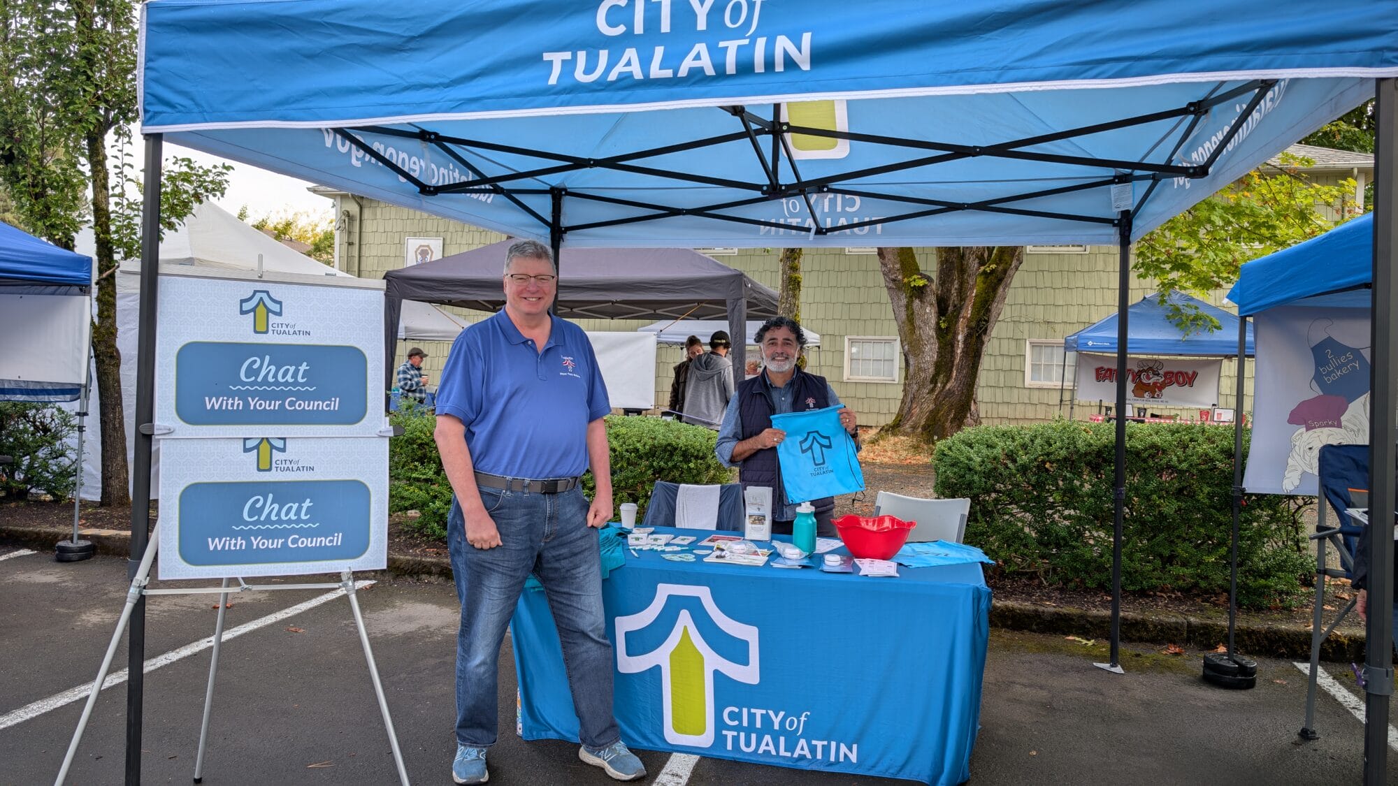 Mayor Bubenik and Councilor Gonzalez standing under a Tualatin-branded canopy