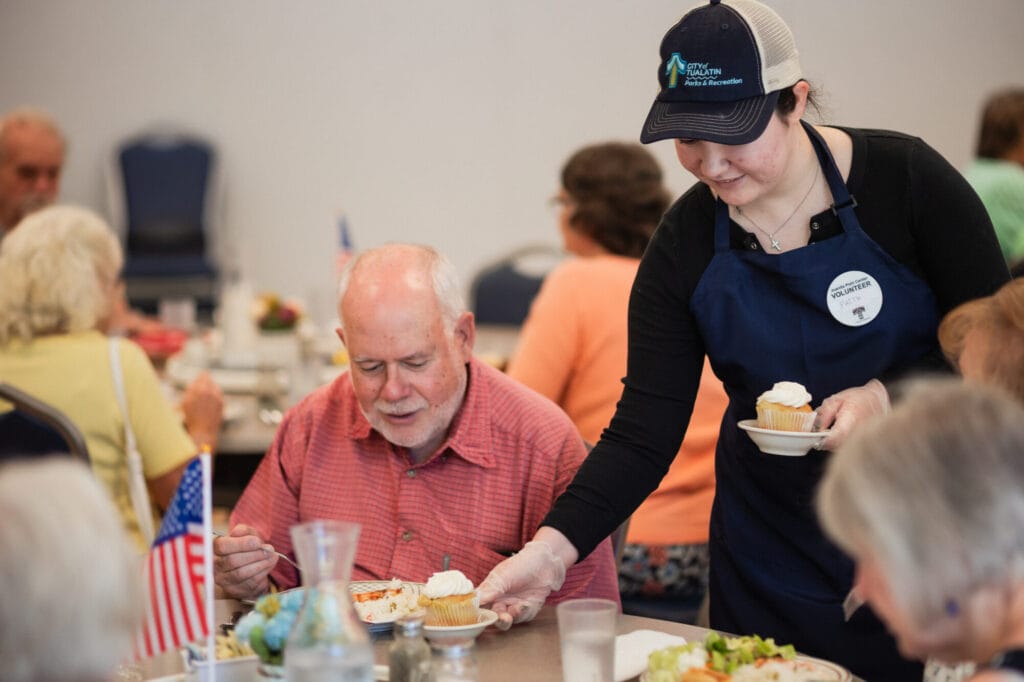 Volunteer serving food to a senior