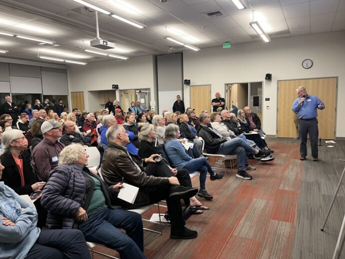 Crowd sitting in chairs watching a presenter