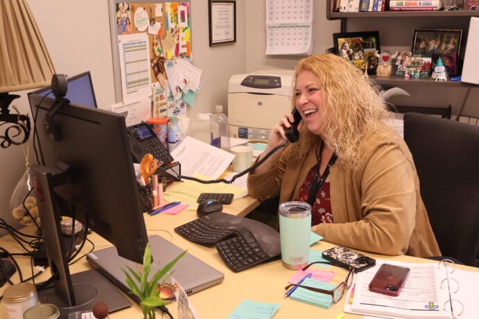 Woman on the phone looking at computer