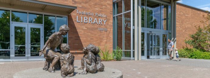 Father and young son walk into Tualatin Public Library